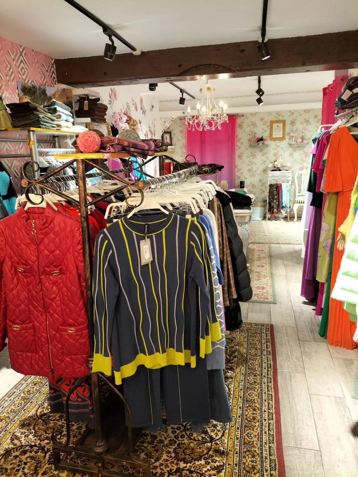Percha con chaqueta roja acolchada y jersey de rayas de la nueva temporada