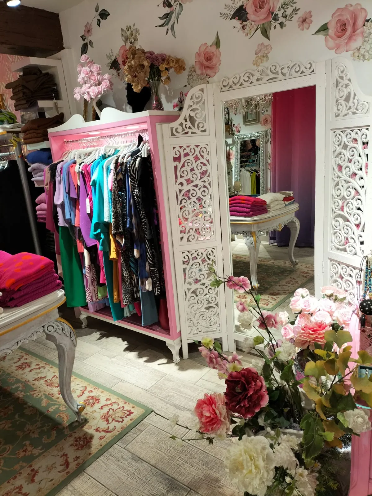 Rincón de la tienda con armario rosa y espejo decorativo