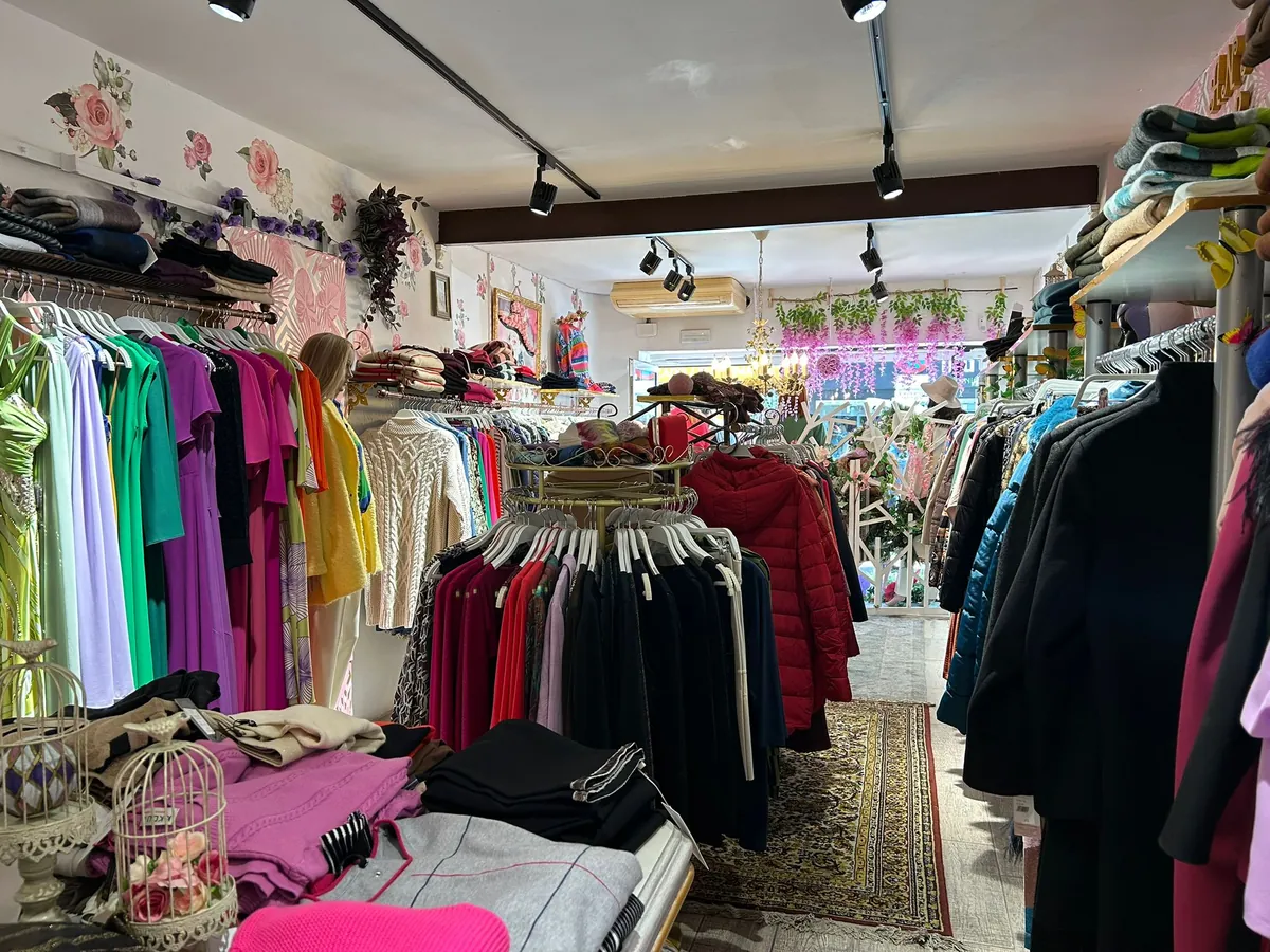 Interior de la tienda con perchas de ropa variada
